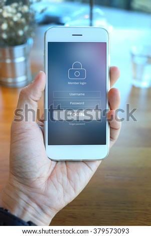 Hand holding smartphone with mebber loging screen on coffee shop background