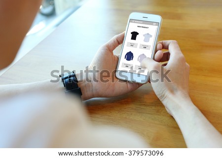 Man holding smartphone with choose shirt on ecommerce website Royalty-Free Stock Photo #379573096