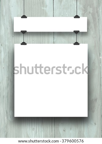 Close-up of two hanged paper sheet frames with clips on aqua painted weathered wooden boards background