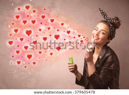 Pretty young girl blowing valentine red heart symbols 