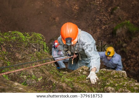 Caver descends into the cave. Royalty-Free Stock Photo #379618753