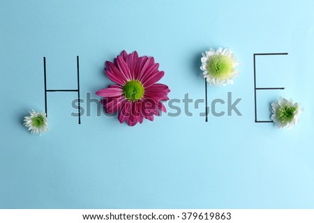 Inscription hope with pink and white flowers on blue background