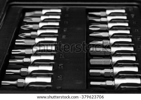 Set of screwdriver torx bits on socket toolbox. Closeup precision small tools on black background