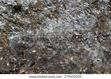 Photo closeup of costal beach sharp cracked brown rock stone formations covered with salt minerals solid layer on natural background, horizontal picture 