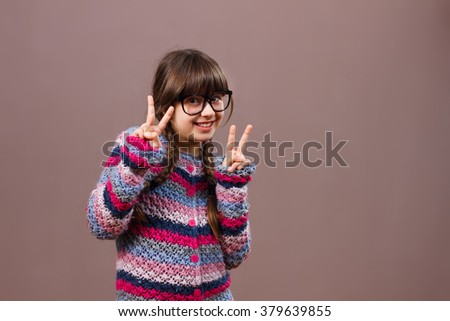 Cute little nerdy girl is showing peace sign.I am for peace!