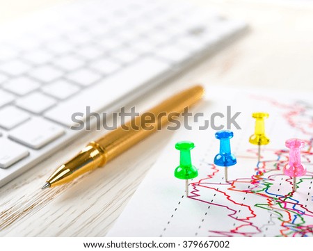 Pen, keyboard and pins on graph paper, business success concept
