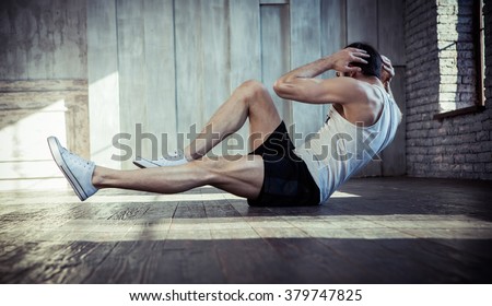 Young fit man exercising in a gym Royalty-Free Stock Photo #379747825