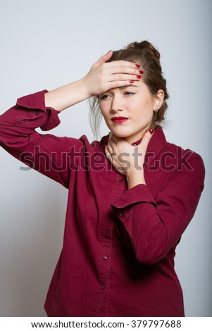 Beautiful girl has a sore throat isolated on a gray background