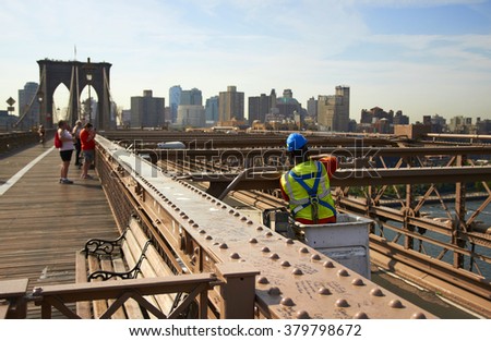 A construction worker on Brooklyn Bridge at busy sunny day. Royalty-Free Stock Photo #379798672