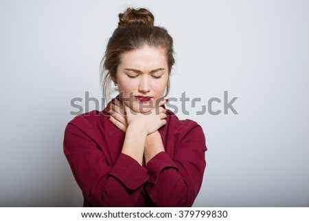 Beautiful girl has a sore throat isolated on a gray background