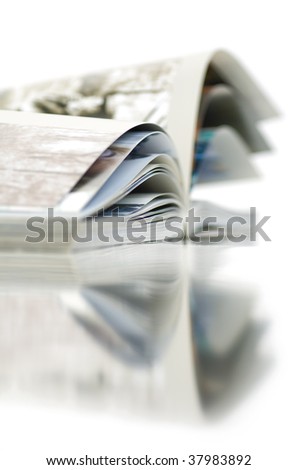 Soft focus view of opened color magazine with reflection. Close-up.