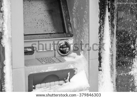 Atm machine covered with snow. Black and white picture of functional bank atm machine covered with ice and snow.