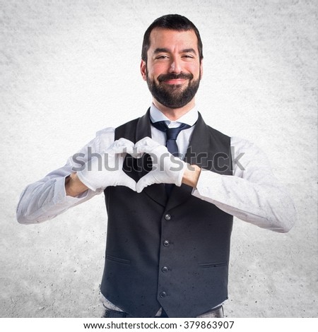 Luxury waiter making a heart with his hands