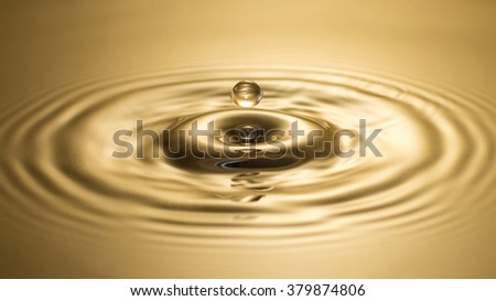 close-up of droplet splash in a golden water