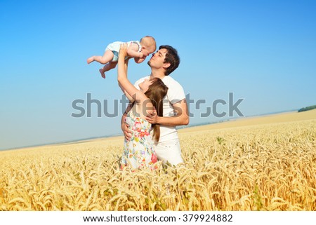 Family portrait. Picture of happy loving father, mother and their baby outdoors. Daddy, mom and child against summer blue sky.