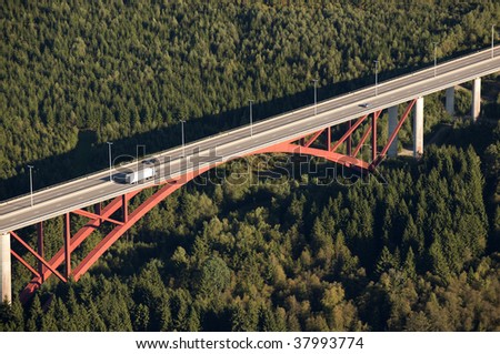 Aerial view : Red highway bridge crossing a big forest