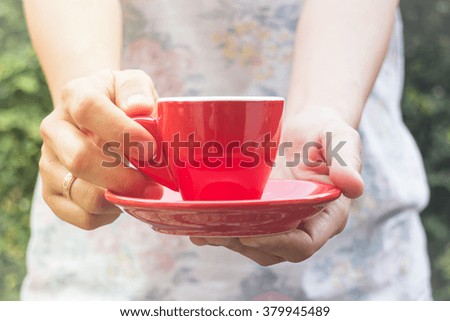 Hand on cup of coffee with vintage filter, stock photo