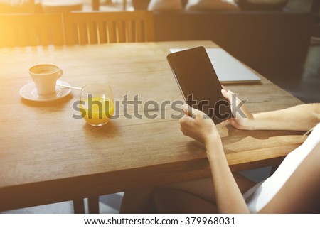 Closely image of woman's hands holding touch pad with blank copy space screen for your advertising text message or content, young female watching video on digital tablet while waiting friends in cafe