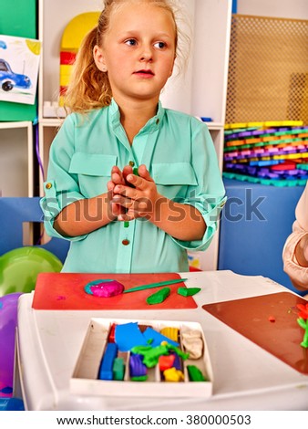 Kid molds from plasticine on craft lesson   in kindergarten .