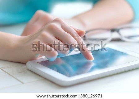 Hand touching screen on modern digital tablet pc. Royalty-Free Stock Photo #380126971