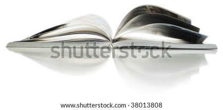 Soft focus view of opened color magazine with reflection. Close-up.