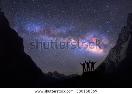 Into the stars. Three people, standing together, holding hands, against the Milky Way Galaxy. Nepal, sagarmatha national park, Everest region, Thame - 3750 m