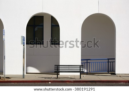 A park bench is facing a passage with arches / Passage with arches        