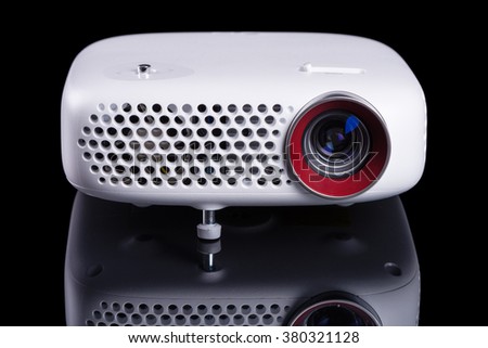 Stylish mini home cinema LED projector, lightweight tech gadget.