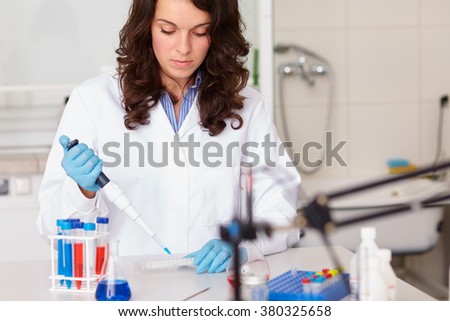 Young female lab technician works on some samples