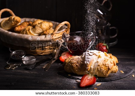 Fresh almond croissants strewing by sugar powder, vintage style. Selective focus