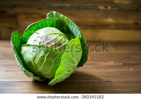 Fresh green garden cabbage on rustic wooden background Royalty-Free Stock Photo #380345182