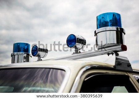Old police car round domed rotating blue emergency lights on a 1960s police car