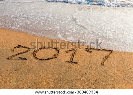 New Year 2017 is coming concept - write  2017 on a beach sand Royalty-Free Stock Photo #380409334