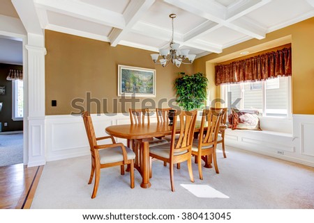 SImple dinning room with white carpet and beige walls.