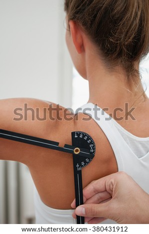 Physiotherapist measure shoulder flexion with goniometer of young female
