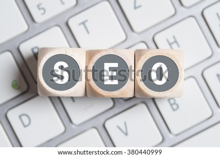 cubes with the acronym SEO for search engine optimization on a keyboard