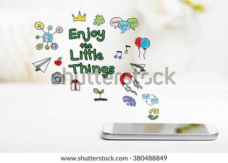 Enjoy The Little Things concept with smartphone on white table