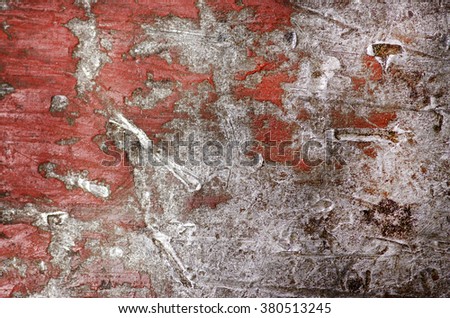 Background of peeling paint and rusty old red metal.