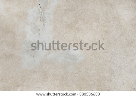 Smooth beige concrete surface with a crack