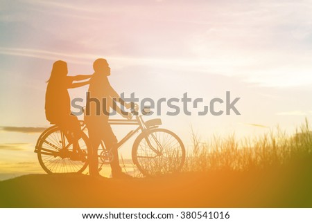 silhouette of sweet young couple in love happy time on bicycle
