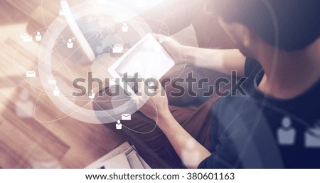 Photo of businessman touching screen Of generic design tablet holding in his hands. Laptop on the floor. Digital interface effect. Wide mockup