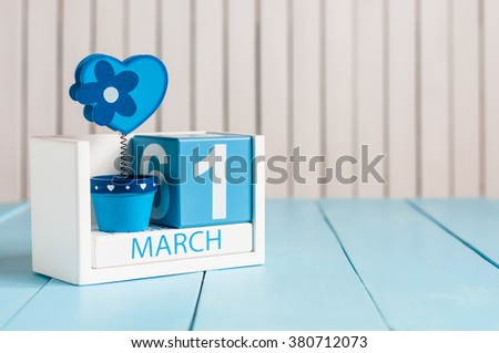 March 1st. Image of march 1 wooden color calendar with flower and heart on white background.  First spring day.