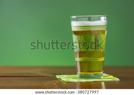 St. Patricks Day cold, frosty glass of beer on a rustic wood background