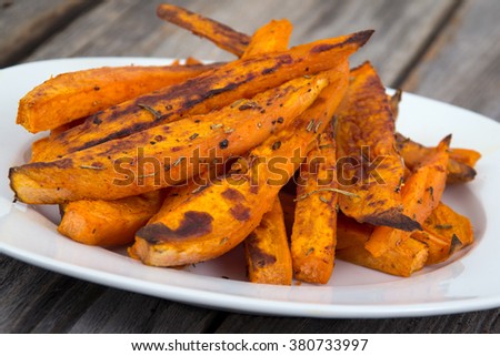 Sweet potato fries wedges closeup on wooden table