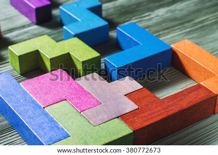 The concept of logical thinking. Geometric shapes on a wooden background. 
Tetris toy wooden blocks. Royalty-Free Stock Photo #380772673