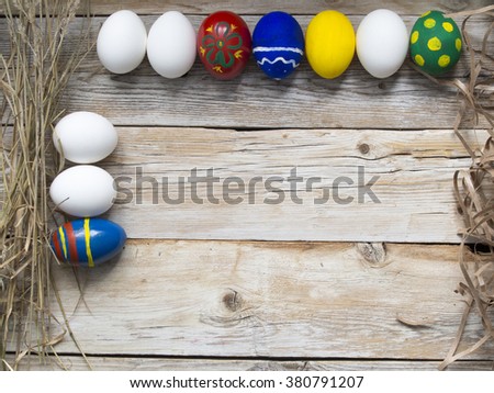 Colorful Easter egg border against wood background.

