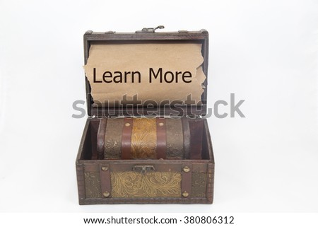 learn more is written on the brown torn paper in the treasure box. isolated on white background