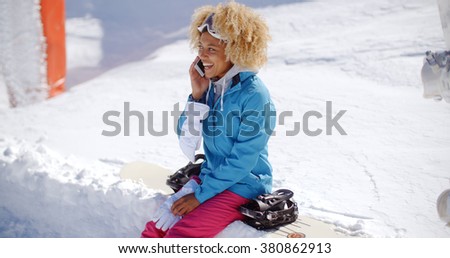 Laughing woman chatting on her mobile in snow
