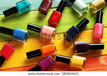 Bottles of nail polish on a colorful wooden table Royalty-Free Stock Photo #380869621
