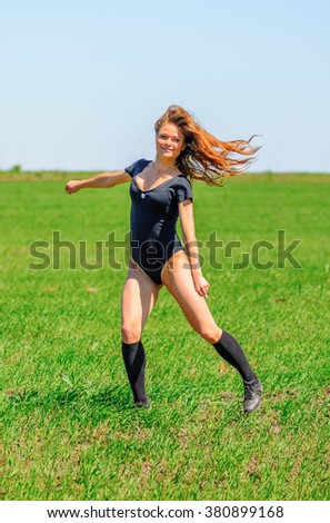 Young sportive girl show acrobatic tricks on the grass